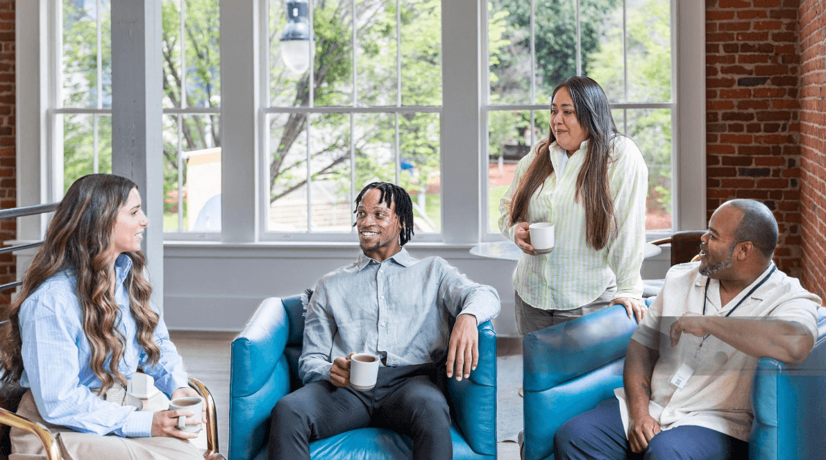 A group of community members chatting together over coffee