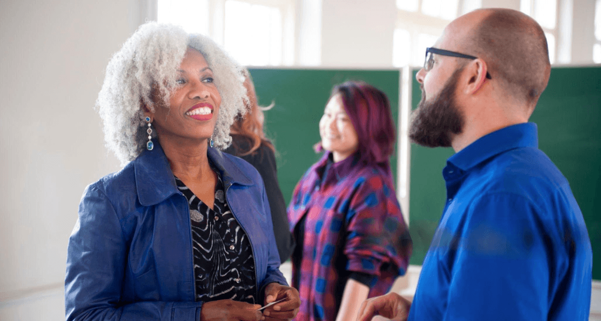 A woman talking with a colleague, with others nearby