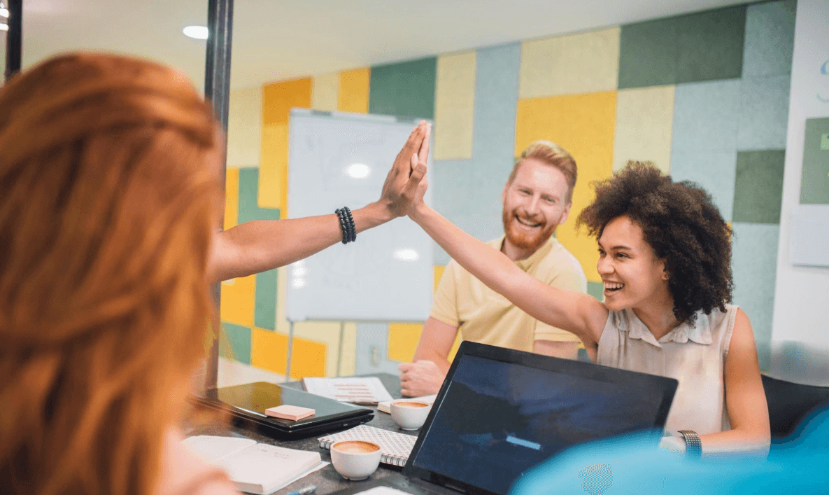 Colleagues celebrating with a high five in an office